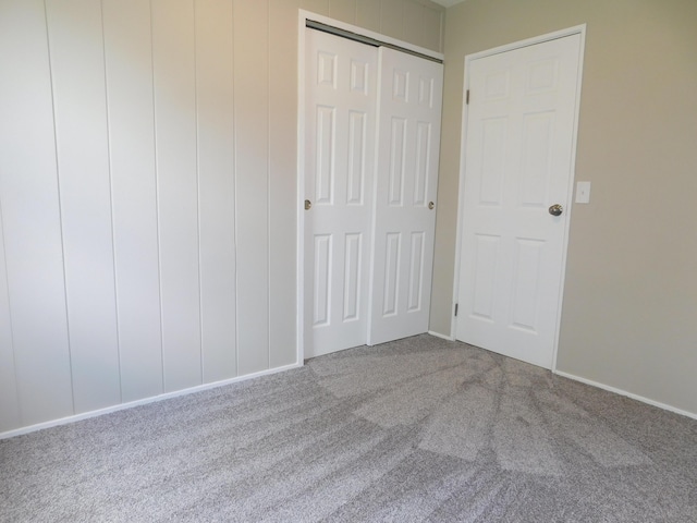 unfurnished bedroom featuring carpet flooring, a closet, and baseboards