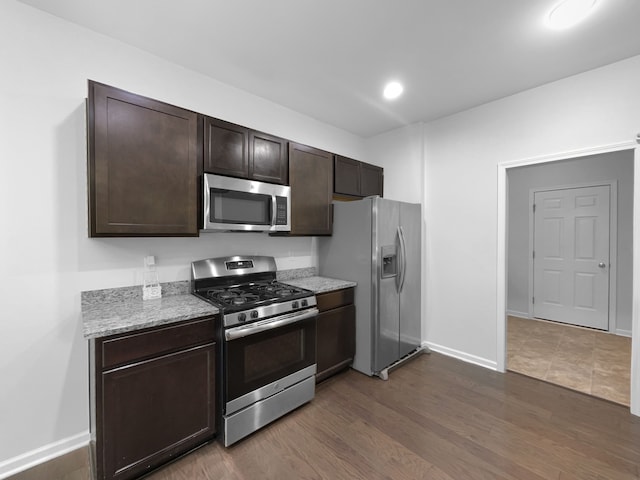 8351 Ardmoor Dr, Ypsilanti, MI 48198 - kitchen featuring stainless steel appliances, light stone counters, dark wood-style flooring, baseboards, and dark brown cabinets