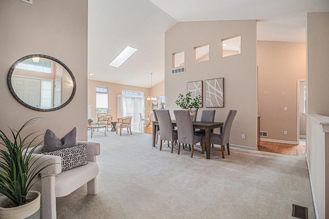 dining area with carpet flooring, visible vents, baseboards, and high vaulted ceiling