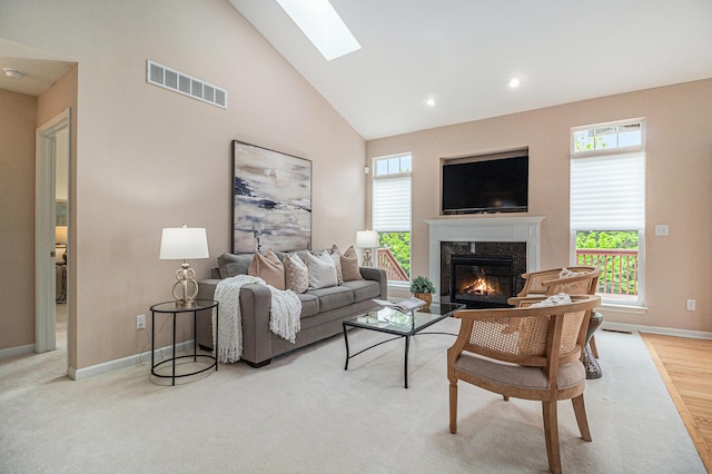 living room with high vaulted ceiling, visible vents, baseboards, and a high end fireplace