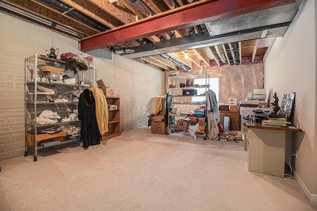 basement featuring carpet flooring and brick wall