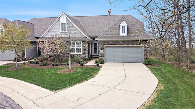 craftsman-style home with an attached garage, a front yard, stone siding, and driveway