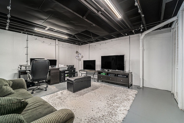 living area with finished concrete flooring and a textured wall