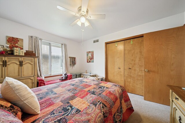 bedroom with light carpet, a ceiling fan, and a closet