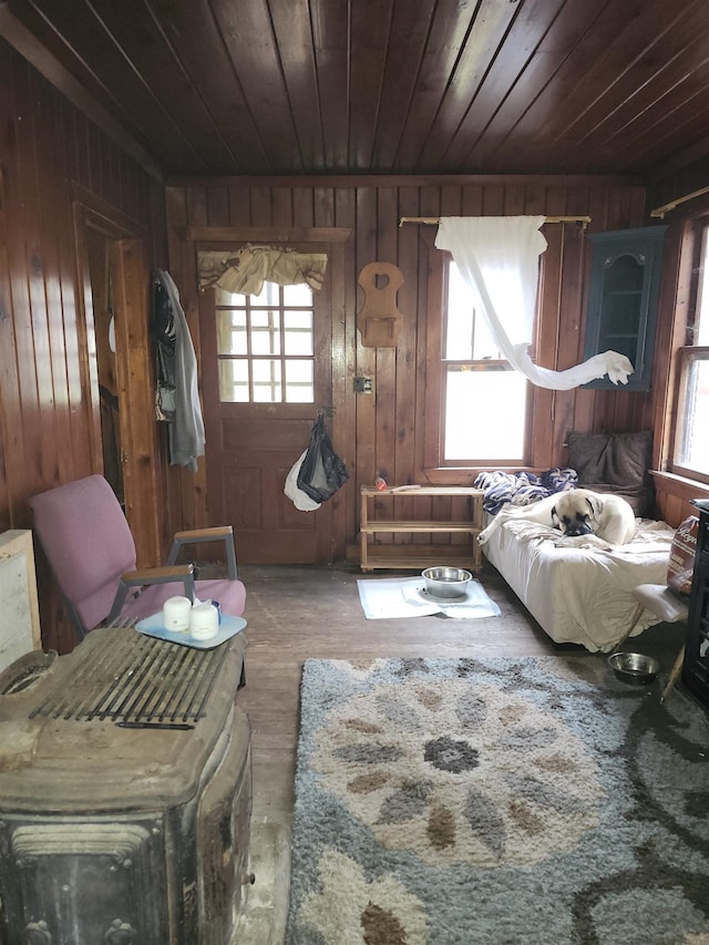 bedroom with multiple windows, wood walls, and wooden ceiling