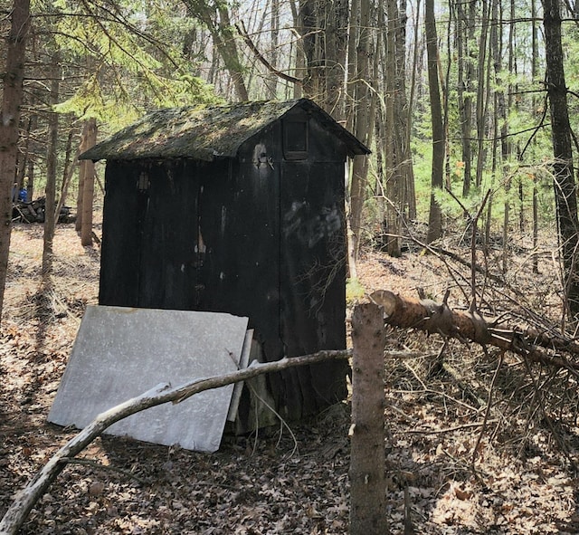 view of shed with a view of trees