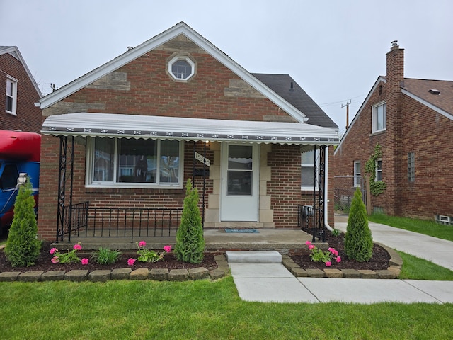 view of front facade with brick siding and covered porch