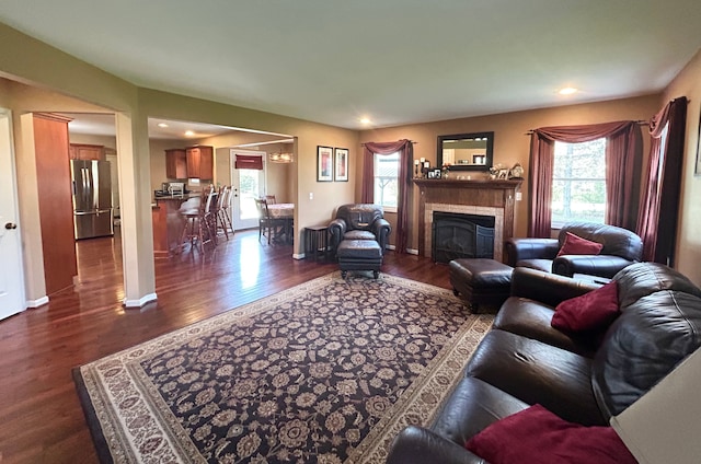 living area with recessed lighting, dark wood finished floors, baseboards, and a glass covered fireplace