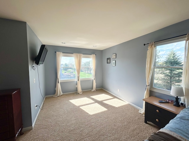 bedroom featuring baseboards and light carpet