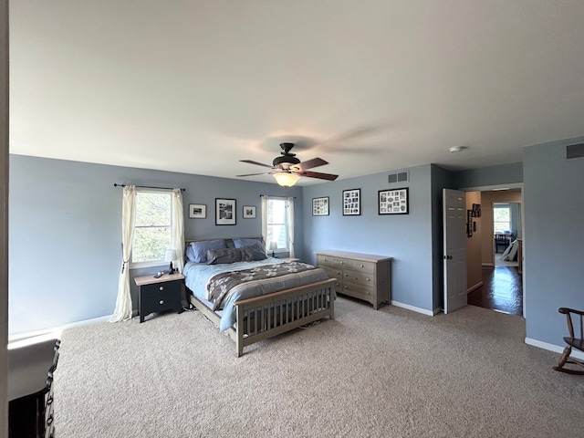 carpeted bedroom with baseboards, a ceiling fan, and visible vents
