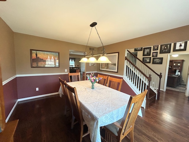 dining space featuring wood finished floors, baseboards, and stairs