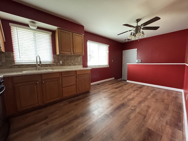 31534 Stricker Dr, Warren, MI 48088 - kitchen featuring a sink, light countertops, ceiling fan, dark wood finished floors, and tasteful backsplash