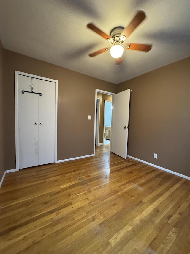 31534 Stricker Dr, Warren, MI 48088 - unfurnished bedroom featuring baseboards, wood finished floors, a ceiling fan, and a closet
