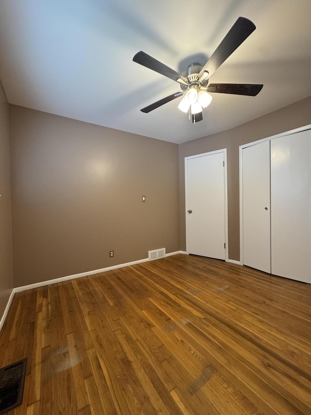 31534 Stricker Dr, Warren, MI 48088 - unfurnished bedroom with wood finished floors, baseboards, two closets, and a ceiling fan