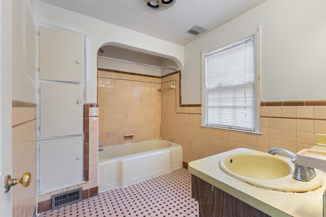 16760 Greenview Ave, Detroit, MI 48219 - bathroom with tile walls, visible vents, wainscoting, and washtub / shower combination