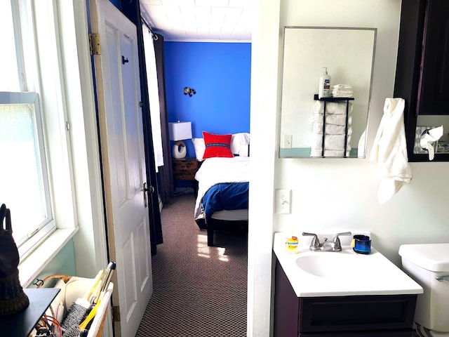 bathroom featuring toilet, connected bathroom, and vanity