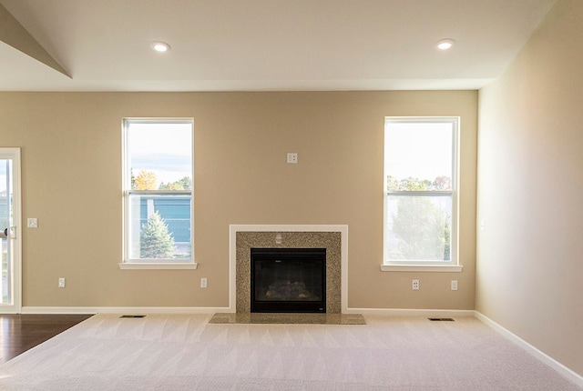 unfurnished living room featuring carpet flooring, baseboards, visible vents, and recessed lighting