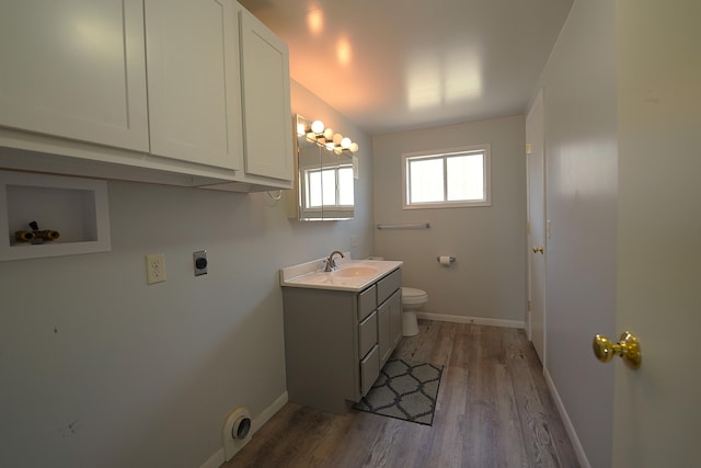 bathroom with toilet, baseboards, wood finished floors, and vanity