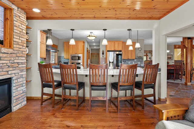 12324 Cranes Ave, Richland, MI 49083 - dining space featuring a stone fireplace, wood ceiling, and wood finished floors