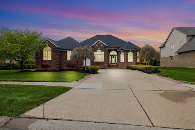 55081 Timberland Ln, Macomb, MI 48042 - french country home featuring brick siding, a front lawn, and driveway