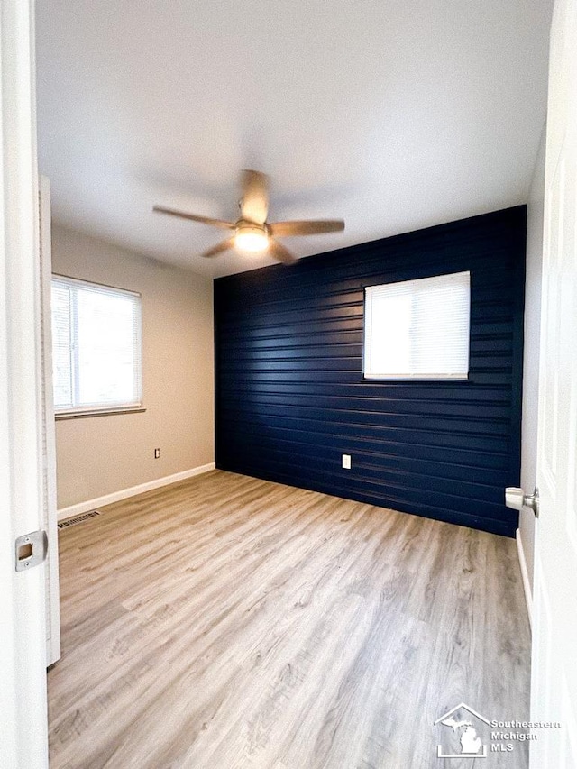 35381 Dern Dr, Rockwood, MI 48173 - spare room with baseboards, ceiling fan, visible vents, an accent wall, and wood finished floors