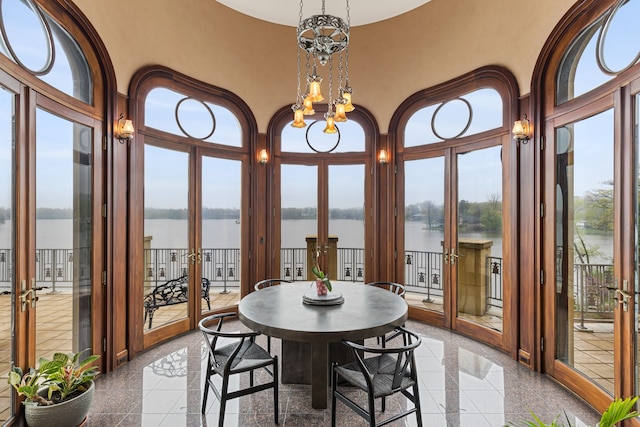 sunroom with french doors and a water view