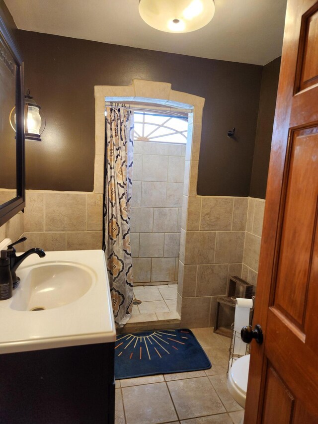 full bath with tile walls, toilet, tiled shower, and tile patterned floors