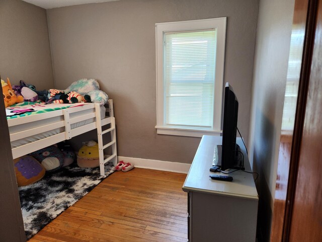 bedroom with baseboards and hardwood / wood-style flooring