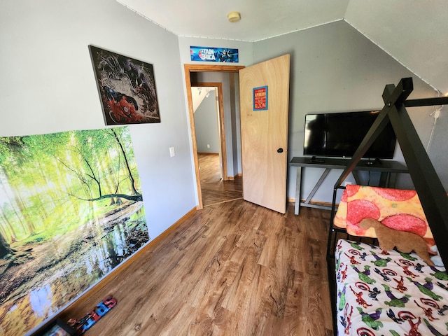 bedroom featuring vaulted ceiling, baseboards, and wood finished floors