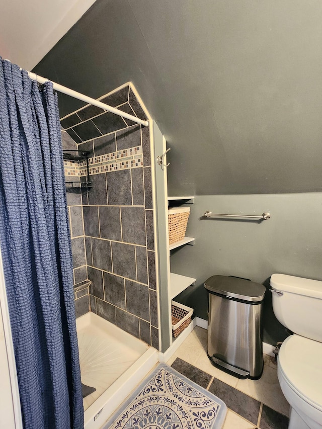 bathroom featuring a shower stall, tile patterned flooring, and toilet