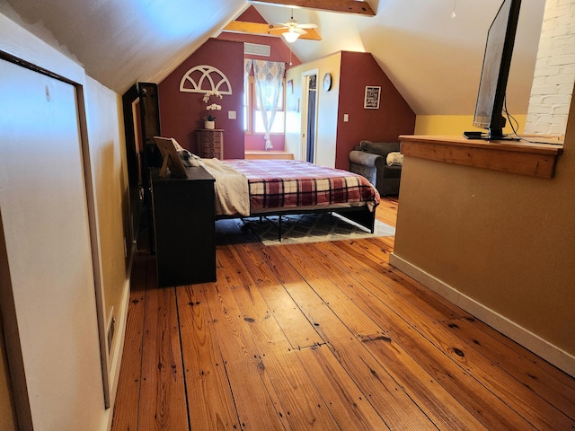 bedroom with light wood finished floors, lofted ceiling, and baseboards
