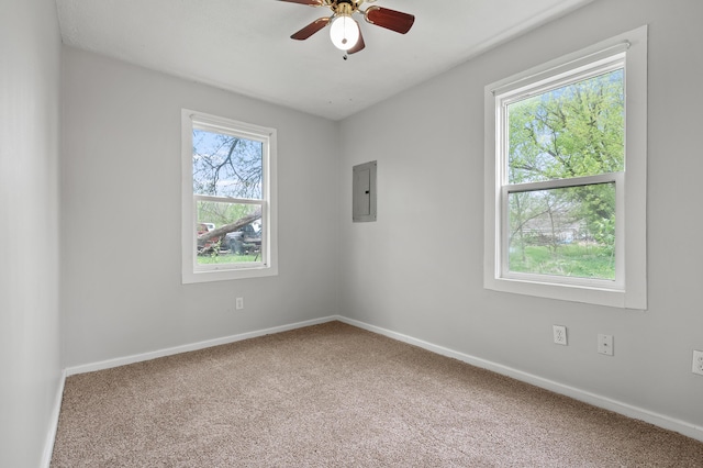 carpeted empty room with electric panel, ceiling fan, and baseboards