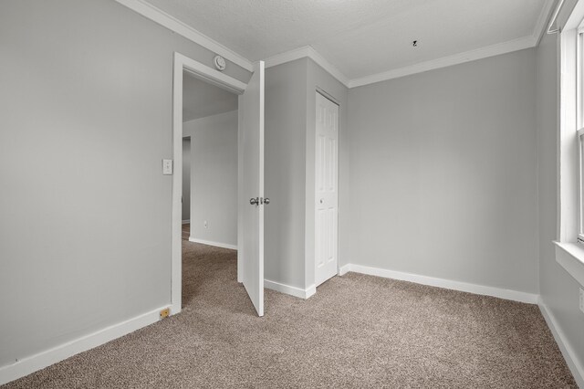 unfurnished bedroom with carpet flooring, baseboards, and ornamental molding