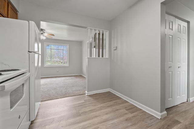 kitchen featuring a ceiling fan, baseboards, white electric range, brown cabinets, and light wood-style floors