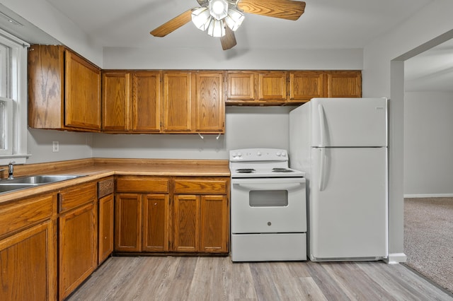 kitchen with brown cabinetry, white appliances, light countertops, and a ceiling fan