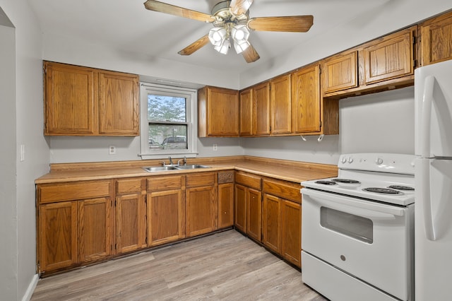 kitchen featuring white appliances, a sink, brown cabinets, light wood-style floors, and light countertops