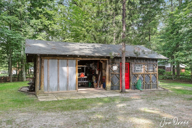 view of outbuilding featuring fence and an outbuilding