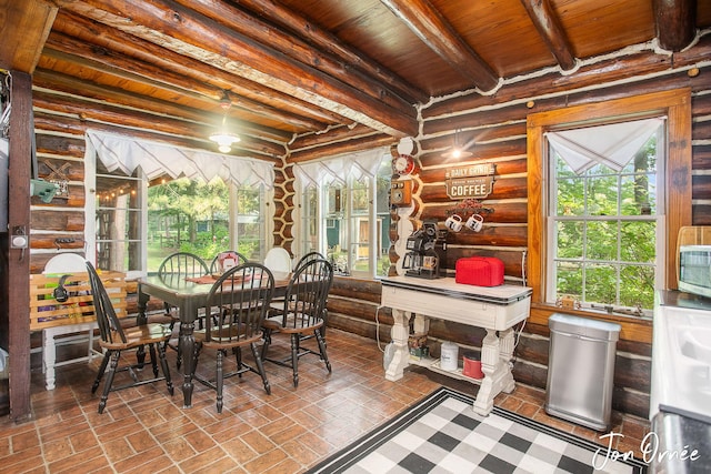 dining area featuring log walls, beam ceiling, and wooden ceiling