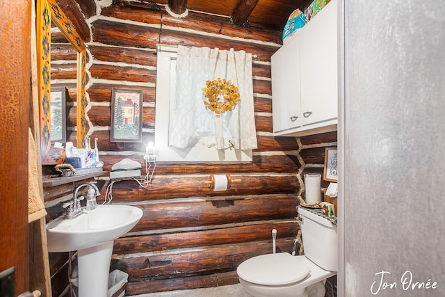 half bath with toilet, log walls, beam ceiling, and wood ceiling