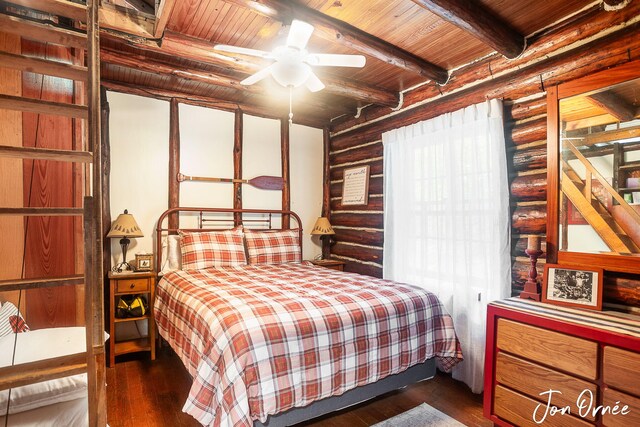 bedroom with log walls, beam ceiling, wooden ceiling, and dark wood-type flooring