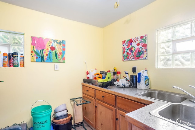 kitchen with a sink, light countertops, and brown cabinets