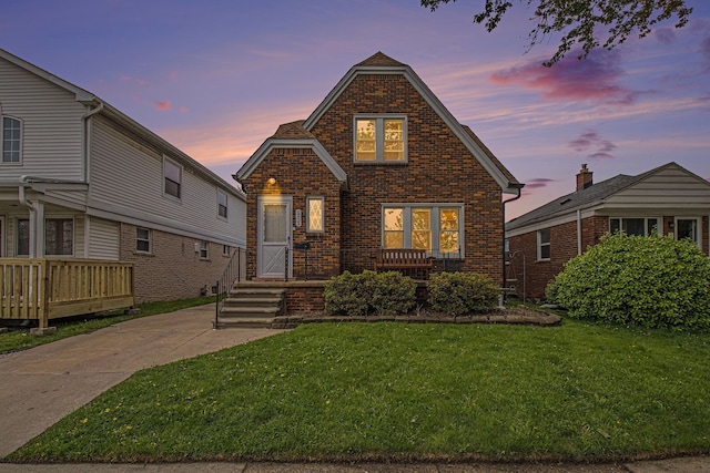 bungalow-style house with brick siding and a lawn