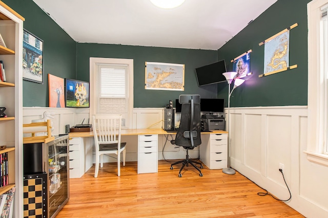 office with wainscoting, light wood finished floors, and a decorative wall
