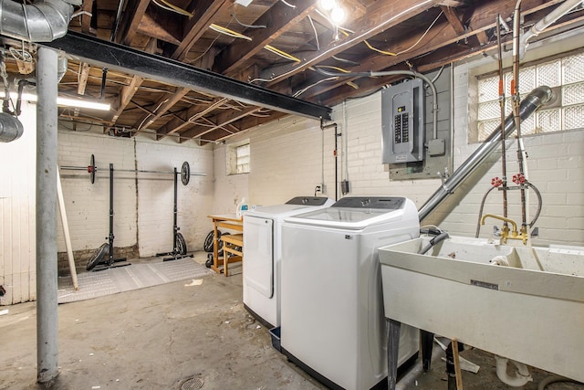 laundry room featuring washer and clothes dryer, electric panel, a sink, laundry area, and a wealth of natural light