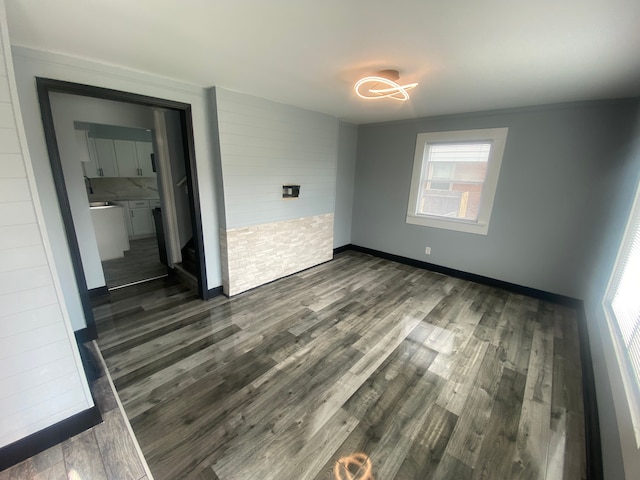 unfurnished bedroom featuring baseboards and dark wood-type flooring