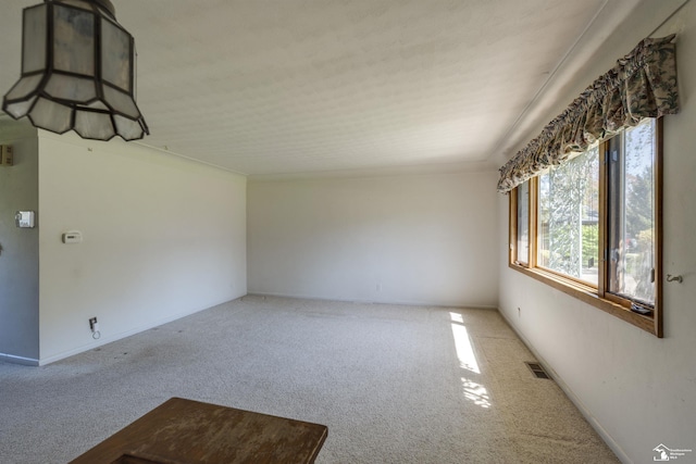 empty room with carpet flooring, visible vents, and baseboards