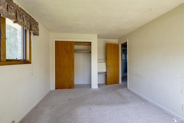 unfurnished bedroom featuring a closet, baseboards, and carpet floors