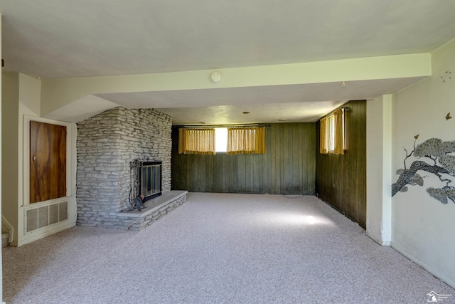 unfurnished living room with baseboards, a fireplace, visible vents, and carpet floors