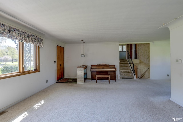 living room featuring stairs, a wealth of natural light, and carpet flooring