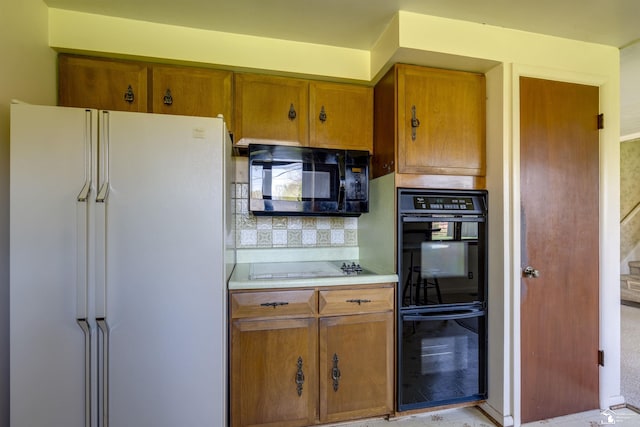 kitchen featuring brown cabinetry, black appliances, light countertops, and decorative backsplash